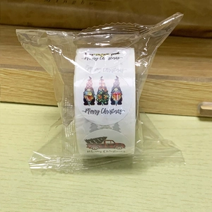 Detail of Christmas roll stickers with gnomes and red trucks in clear plastic packaging