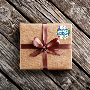 Happy Birthday adhesive stickers on a gift box with a brown ribbon, 45-degree view