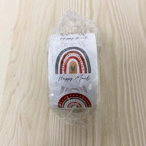 Detailed close-up of rainbow 'Happy Mail' stickers in shrink-wrapped rolls for packaging