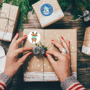 Christmas roll stickers with snowman and reindeer patterns on rustic wooden gift box