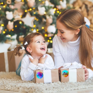Close-up of holographic Merry Christmas stickers on a gift box with a festive background