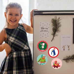 Christmas themed round decorative stickers with Santa and penguin on a white refrigerator