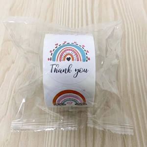 Detail of round rainbow Thank You stickers roll in transparent plastic packaging
