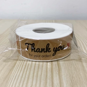 Macro view of round kraft paper stickers with red heart and Thank You for Your Order text
