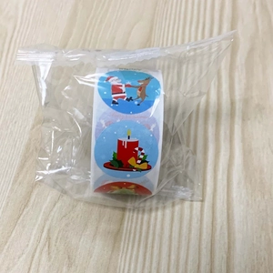 Close-up of roll of Merry Christmas round stickers featuring Santa and reindeer designs