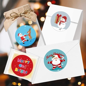 Christmas round stickers with Merry and Bright text on white envelopes with warm bokeh lights