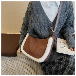 Detail of coffee brown suede half-moon bag with white faux fur trim and slim strap