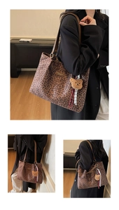 Détail du sac cabas léopard avec pendentif ours en peluche et bandoulière en cuir