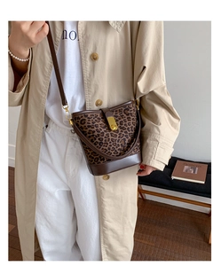 Détail du sac seau à imprimé léopard avec base en cuir et bandoulière réglable