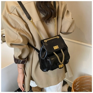 Detailaufnahme des schwarzen glänzenden Mini-Rucksacks mit goldener Kette und Drehverschluss