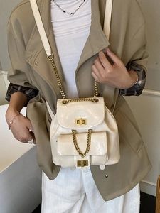 Gesteppter cremefarbener Mini-Rucksack mit Goldkette und Drehverschluss zum Trenchcoat