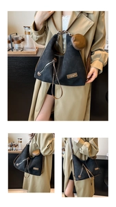 Detail of black suede hobo bag with brown leather strap and detachable round coin purse