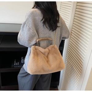 Detail of khaki faux fur handbag featuring a gold chain strap and soft plush texture
