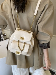Eleganter cremefarbener Rucksack mit Kettenträger und goldfarbenem Drehverschluss