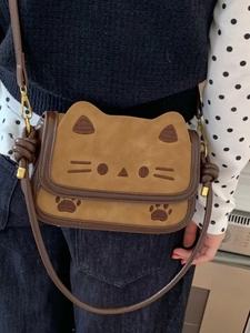 Cute cartoon cat crossbody bag with brown embroidery detail shown on a model