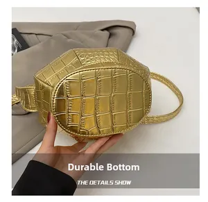 Detail showing the wear-resistant base of the golden crocodile texture bucket bag