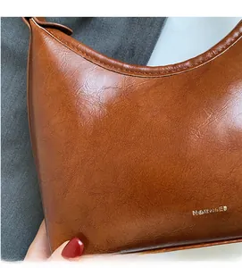 Detailed view of the wrinkled texture and NO FILTER logo on the caramel faux leather bag