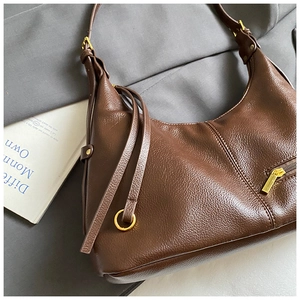 Detail of dark brown lychee pattern leather hobo bag with gold hardware and side zipper