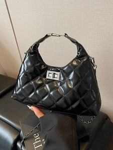Sac à main chic en cuir verni noir matelassé avec fermoir argenté et bandoulière
