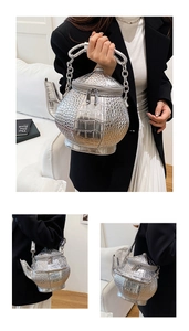 Macro detail of silver teapot-shaped handbag featuring premium crocodile embossed leather texture
