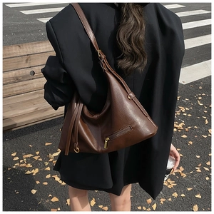 Detail of dark brown pebble leather hobo bag featuring external zipper and gold hardware