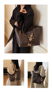Close-up of a dark brown PU leather tote bag featuring a cute rabbit charm and gold logo