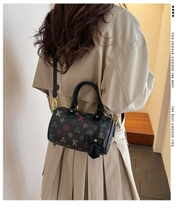 Detailed view of Boston bag with floral pattern and golden hardware on trench coat model