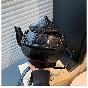 Detail of creative teapot-shaped black crossbody bag with premium crocodile pattern leather