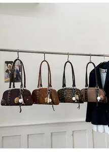 Retro Boston bags with baseball pendants and leopard print detail on metal rack