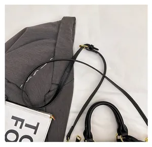 Detail of black leather shoulder strap and handle with gold hardware on a handbag