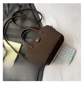 Dettaglio di una borsa a secchiello in camoscio marrone scuro con fibbia in metallo