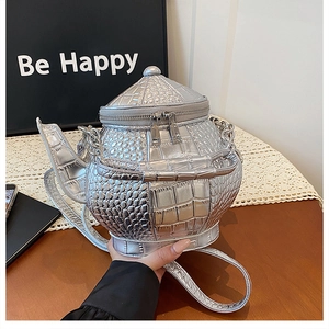 Detail of silver crocodile pattern teapot shaped crossbody bag with metal chain strap