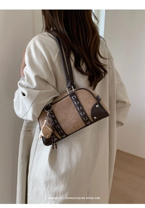 Detail of retro Boston shoulder bag in brown suede with cute cat charm and metal buckle