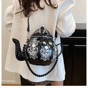 Detail of creative teapot-shaped black crossbody bag with white skull and vine prints