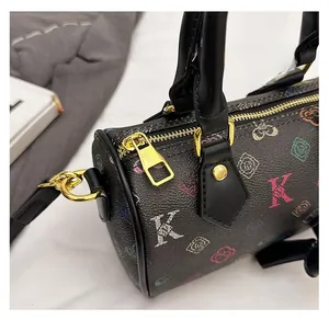 Detail of smooth metal zipper and colorful floral monogram on black pebbled leather bag