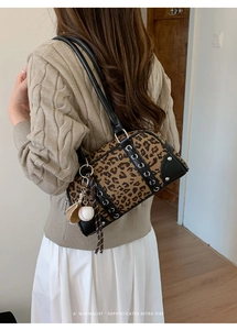 Detail of leopard print bowling bag with creative baseball charm and side lacing