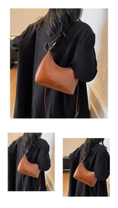 Detail of a brown leather half-moon shoulder bag with white NO FILTER print design