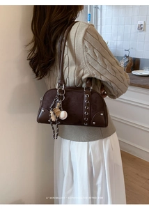 Close-up of retro brown bowling bag with suede texture and baseball glove charm