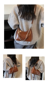 Close-up of brown crescent underarm bag with silver chain and adjustable leather strap