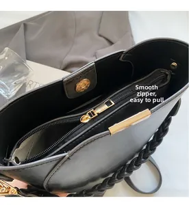 Detail of black faux leather shoulder bag featuring smooth golden zipper and magnetic closure