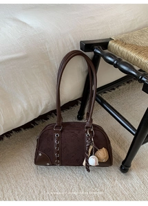 Close-up of retro brown bowling bag with suede panels and baseball theme charm detail