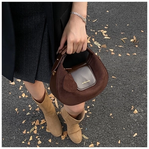 Brown suede hobo bag with leather patchwork and gold hardware in a street style view