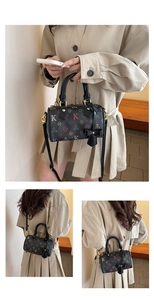 Close-up of Boston bag with colorful floral prints, gold hardware, and bow charm detail