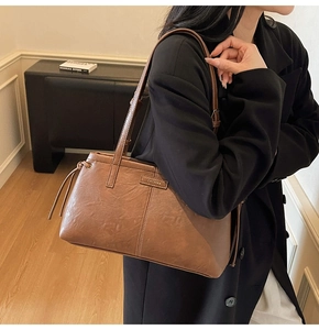 Detailed view of the dark brown leather texture and stitching on this retro shoulder bag