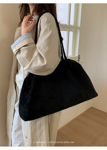 Detail van de zwarte suède shopper met minimalistische stiksels en een slanke schouderband