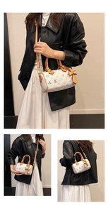 Detail of Boston bag with colorful monogram pattern and brown leather handles and strap
