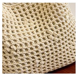Detail shot of the beige hollow mesh weave and soft fabric lining on this tote bag