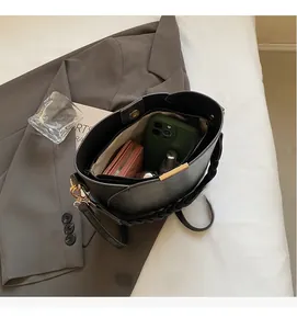 Top view showing the spacious interior of the black leather bucket bag with items