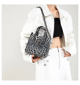 Close-up of leopard print tote featuring silver punk studs and chain embellishments