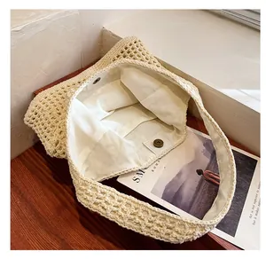Detail of the magnetic buckle and inner canvas pocket of the woven shoulder beach bag